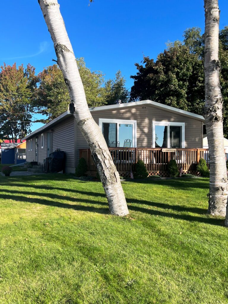 A house with trees in the background and grass