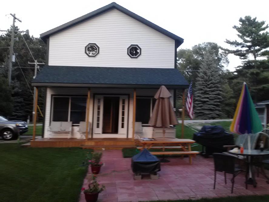 A house with a fire pit and grill in the back yard.