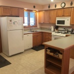 A kitchen with wooden cabinets and white appliances.