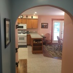 A kitchen with an arched doorway leading to the dining room.