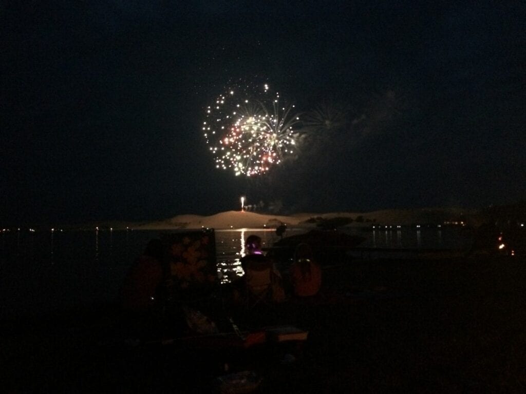 A fireworks display is seen from the beach.