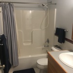 A bathroom with a toilet, sink and bathtub.