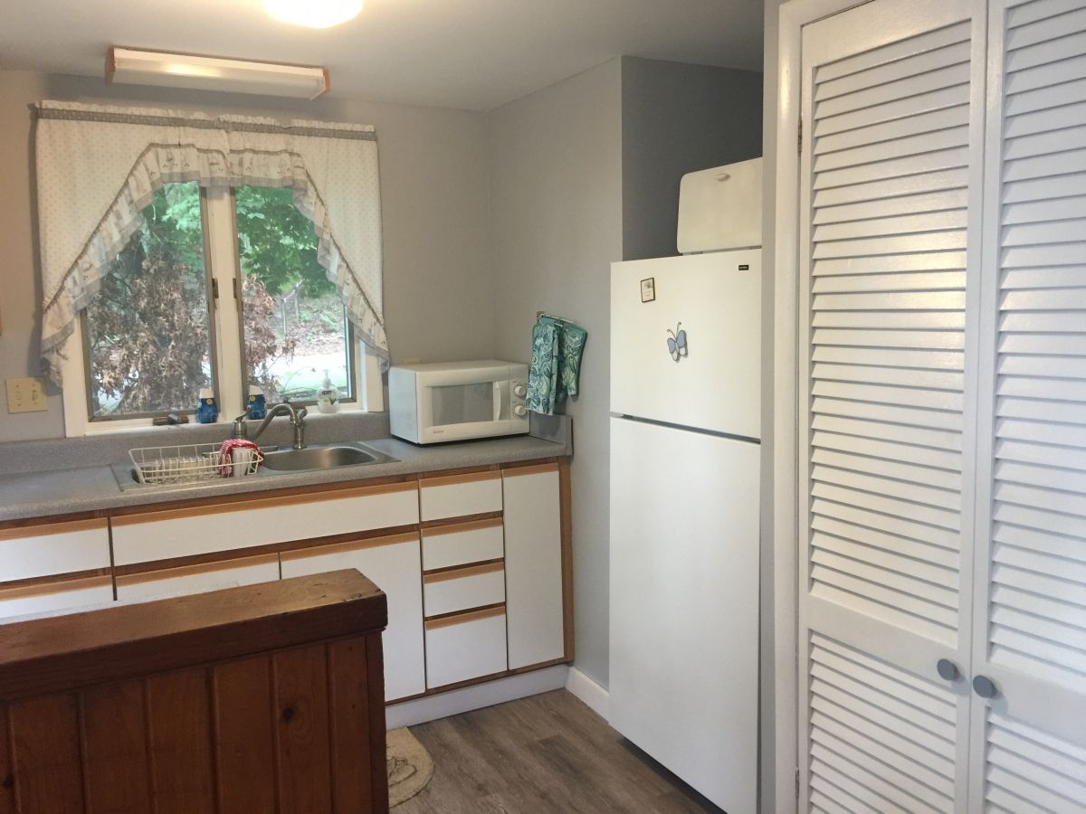 A kitchen with white appliances and wooden cabinets.