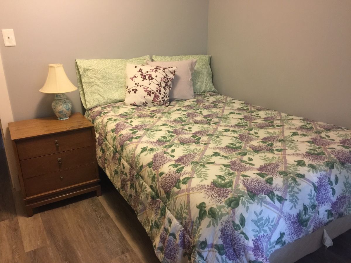 A bed with floral comforter and pillows on it.