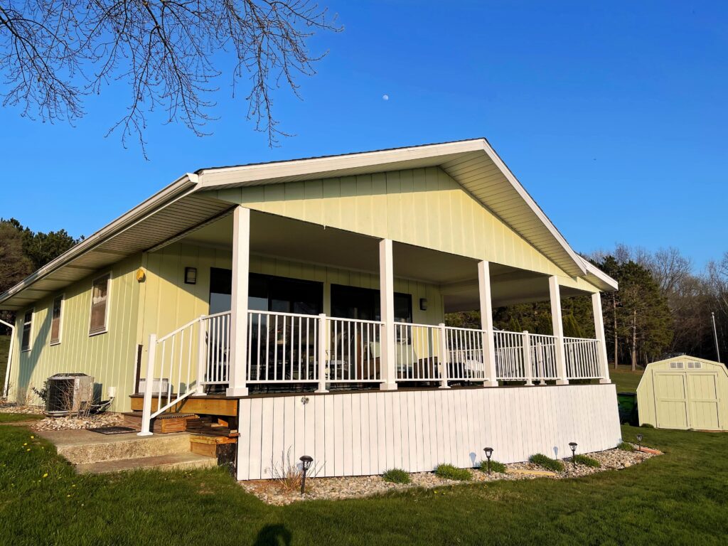 A cream colored cottage with a nearby shed