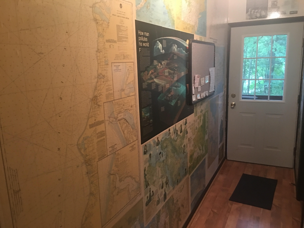 A hallway with many maps on the wall