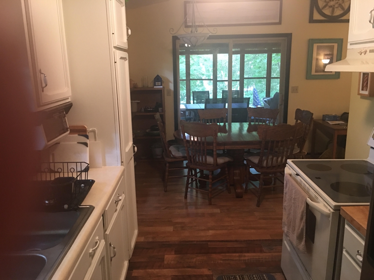 A kitchen with wooden floors and white cabinets.