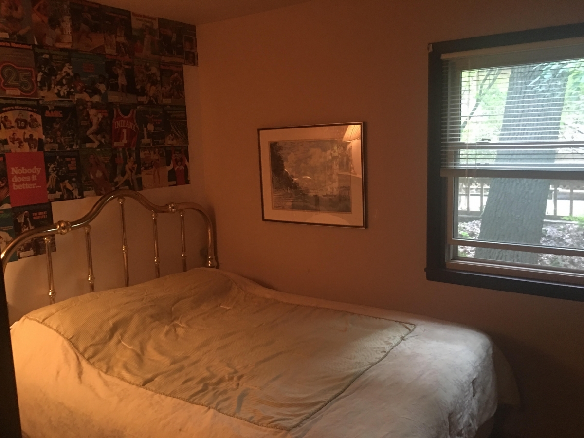 A bed room with a white bedspread and a window