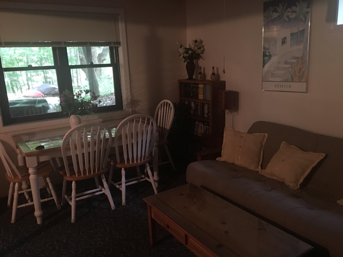 A living room with a couch, table and chairs.