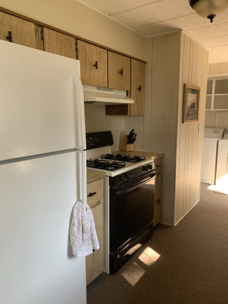 A kitchen with white appliances and wooden cabinets.