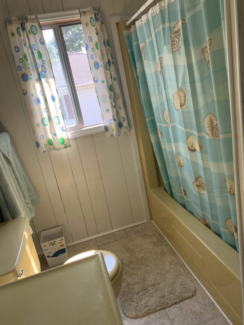 A bathroom with a toilet, sink and shower.