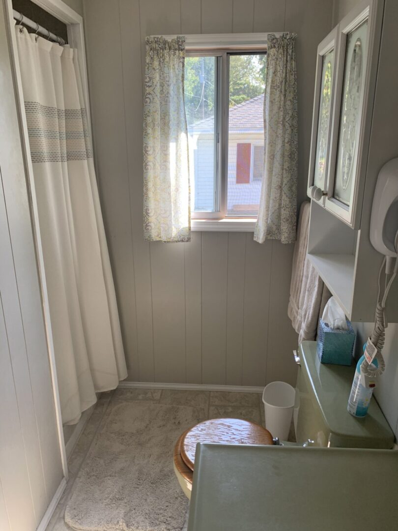 A bathroom with a sink, toilet and mirror.
