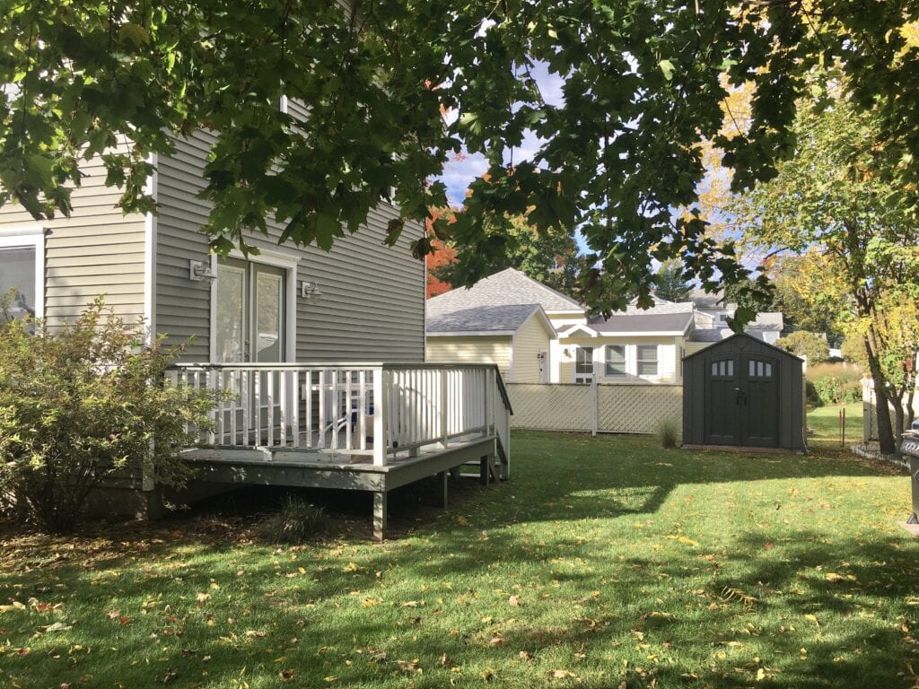 A white deck sitting in the middle of a yard.