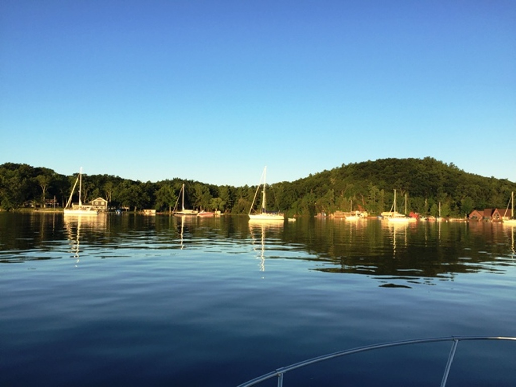 A group of boats in the water near shore.