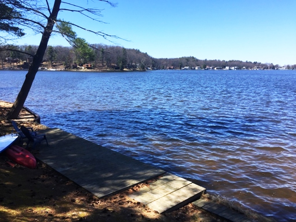 A person sitting on the dock of a lake