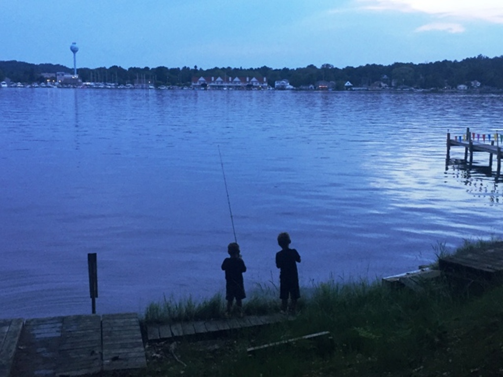 Two kids fishing in a body of water