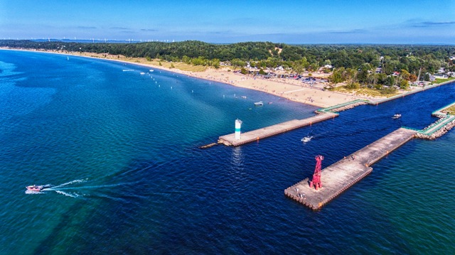 A pier with a lighthouse and some boats in the water