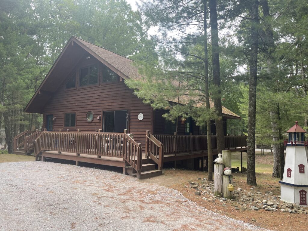 A log cabin with a porch and stairs leading to the front.