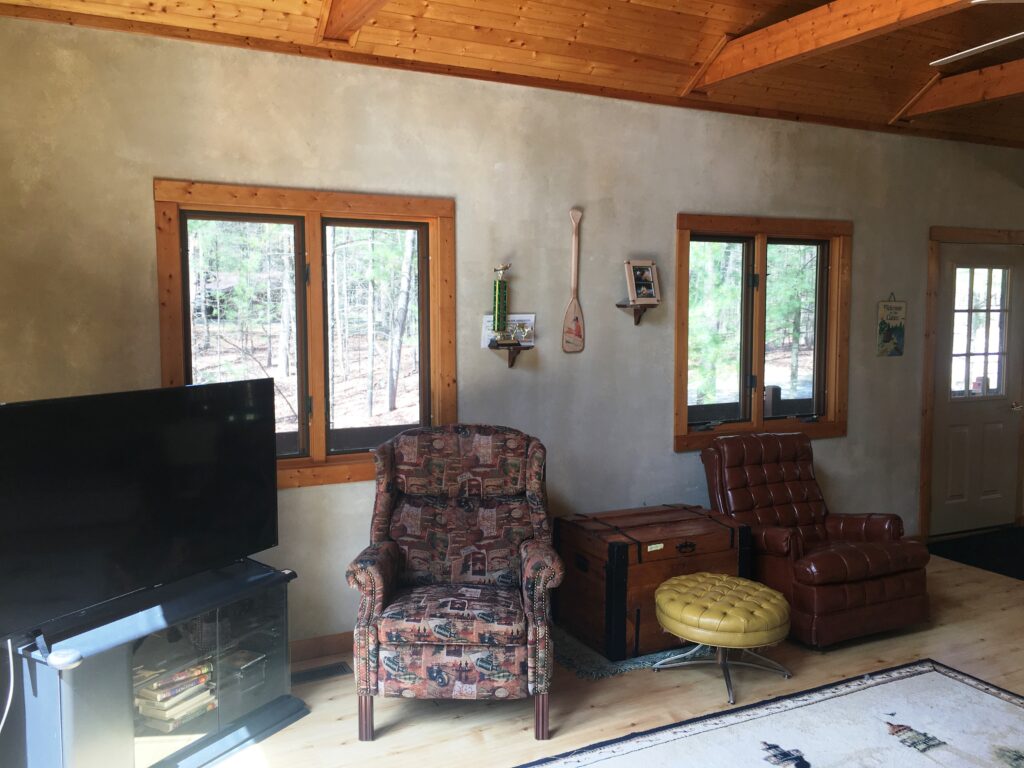 A living room with two chairs and a television.