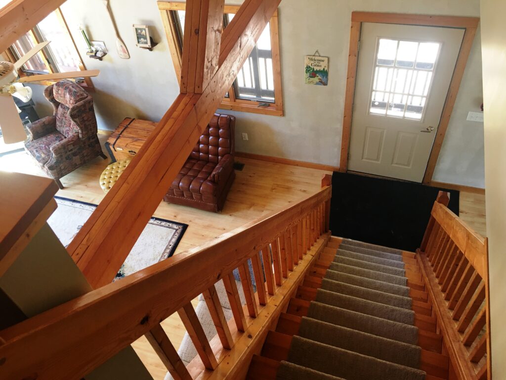A wooden staircase with wood railing and carpet.