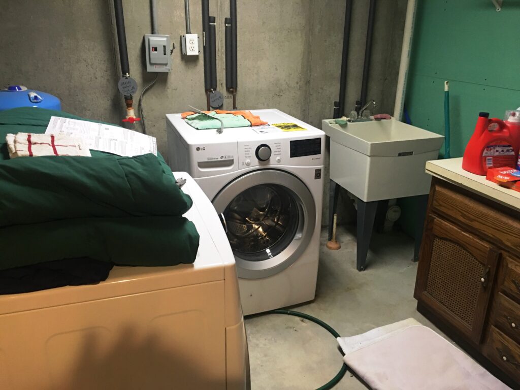 A washer is in the corner of a room.