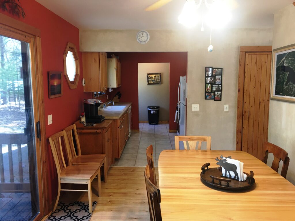 A kitchen with wooden floors and red walls.