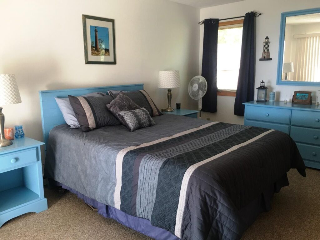 A bedroom with blue furniture and a bed.