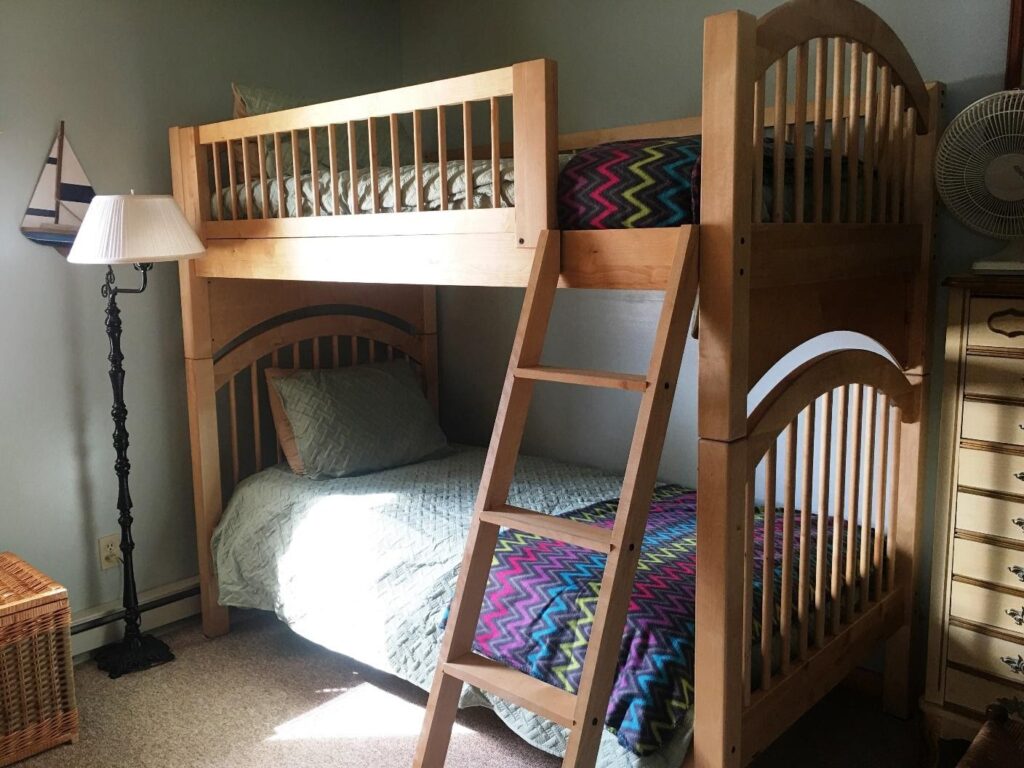 A bunk bed with two sets of ladder in the middle.