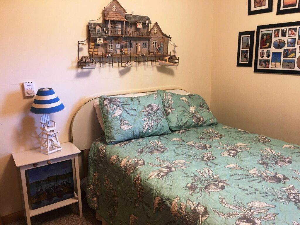 A bed room with a green bedspread and a blue pillow