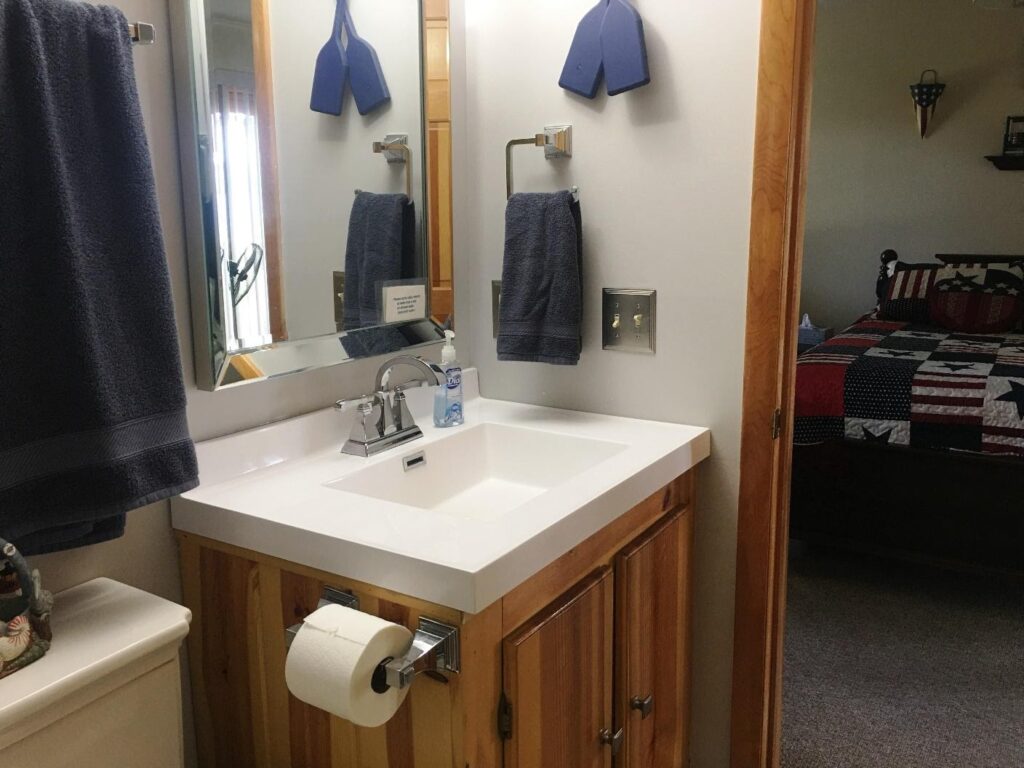 A bathroom with a sink, mirror and toilet.