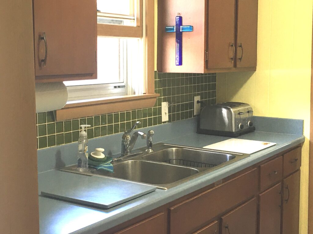 A kitchen with two sinks and a toaster oven.
