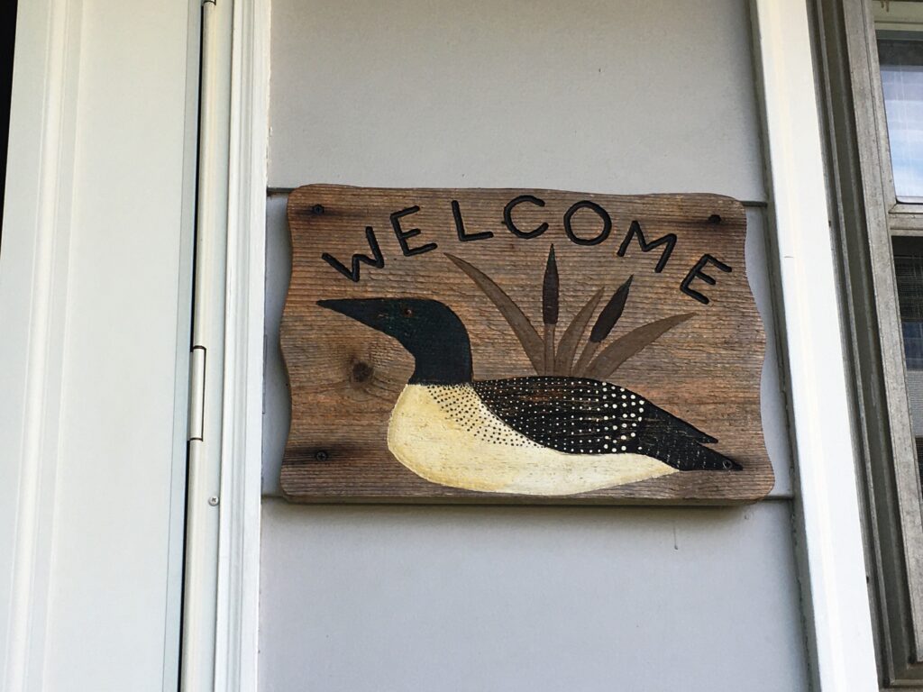 A sign that says welcome with a duck on it.