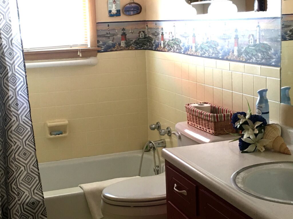 A bathroom with a toilet, sink and bathtub.