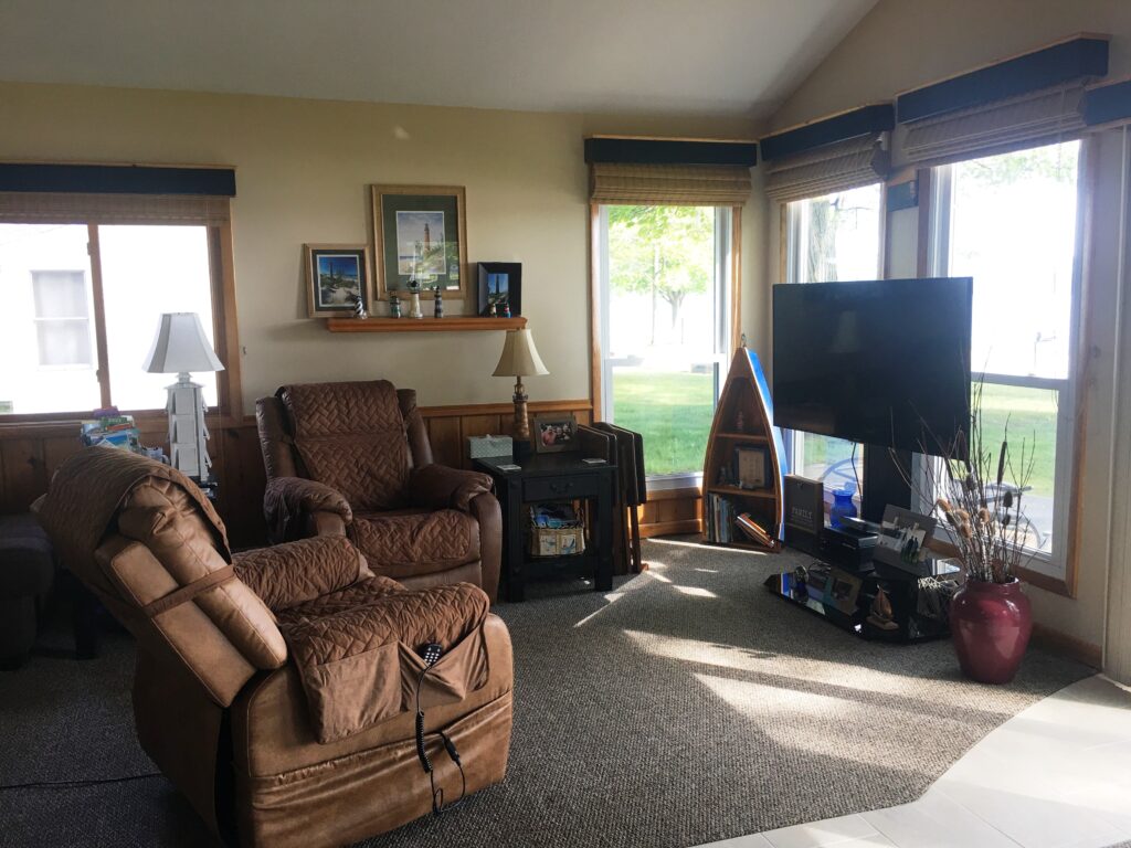 A living room with two brown chairs and a television.