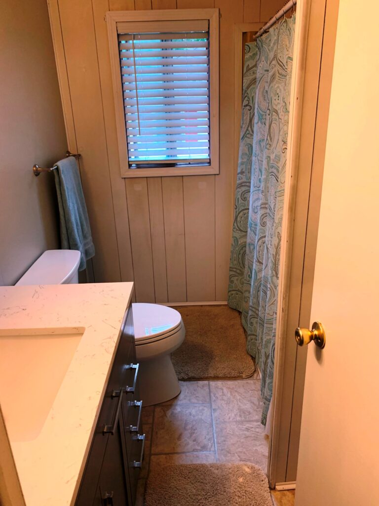 A bathroom with a toilet, sink and shower.