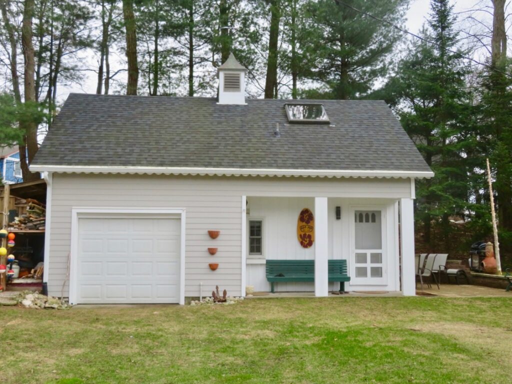 A white garage with a bench in the middle of it.