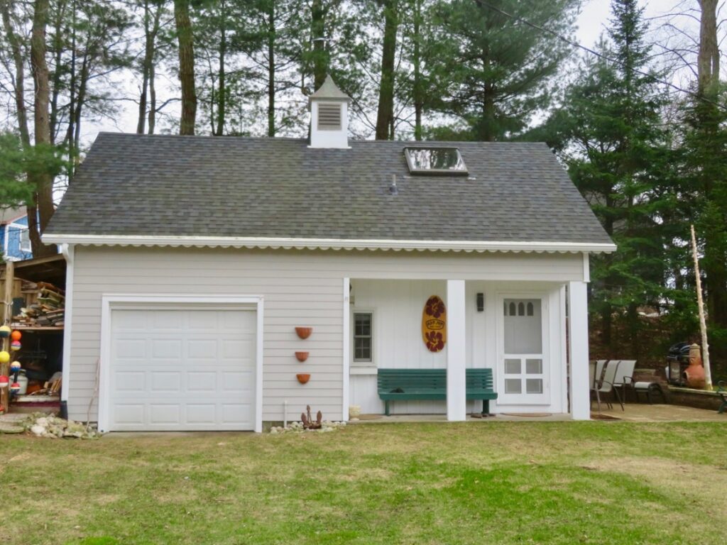 A white garage with a bench in the middle of it.