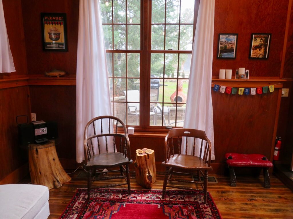 Two chairs in front of a window with curtains.