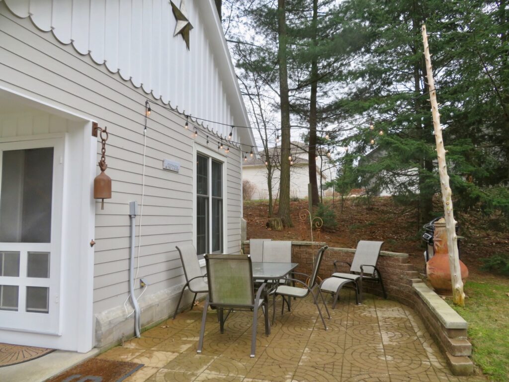 A patio with chairs and tables outside of the house.