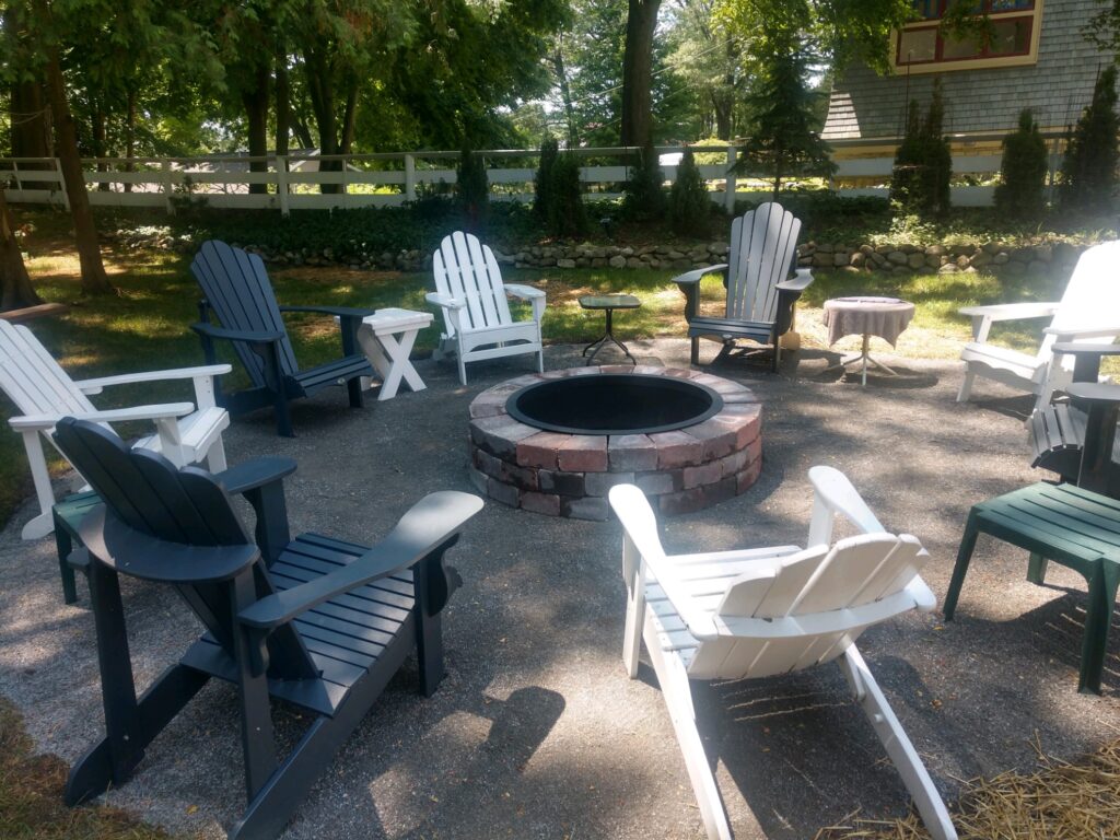 A group of chairs around a fire pit.