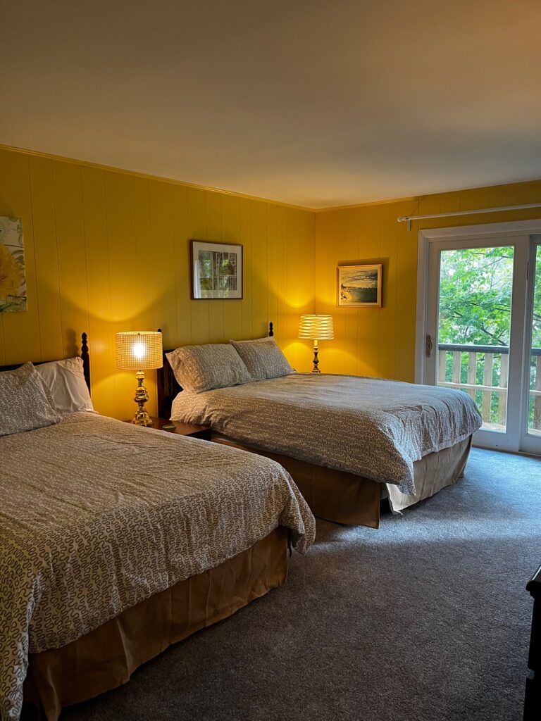 A bedroom with two beds and a balcony