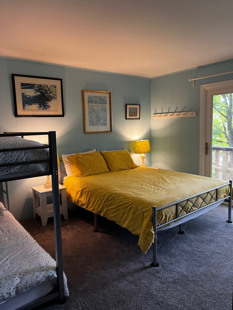 A bedroom with a bed, nightstand and window.