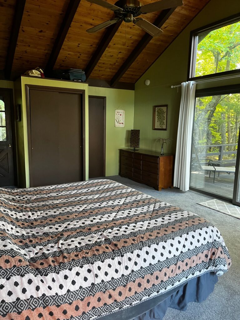 A bedroom with a bed and sliding glass doors.