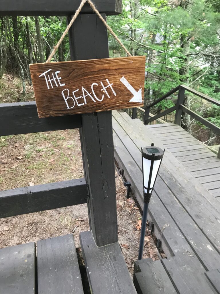 A sign that says the beach with an arrow pointing to it.