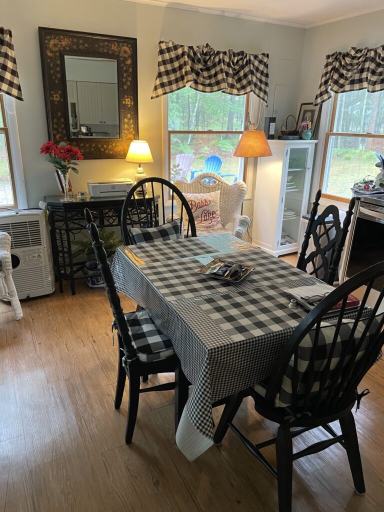 A dining room table with four chairs and a checkered tablecloth.