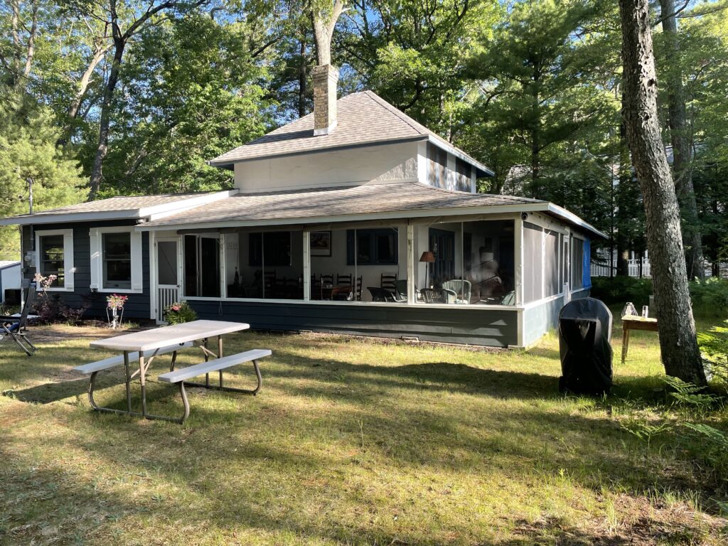 A large house with picnic tables and a grill.