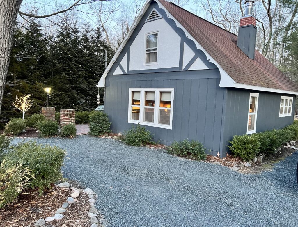 A blue house with a red roof and white trim.