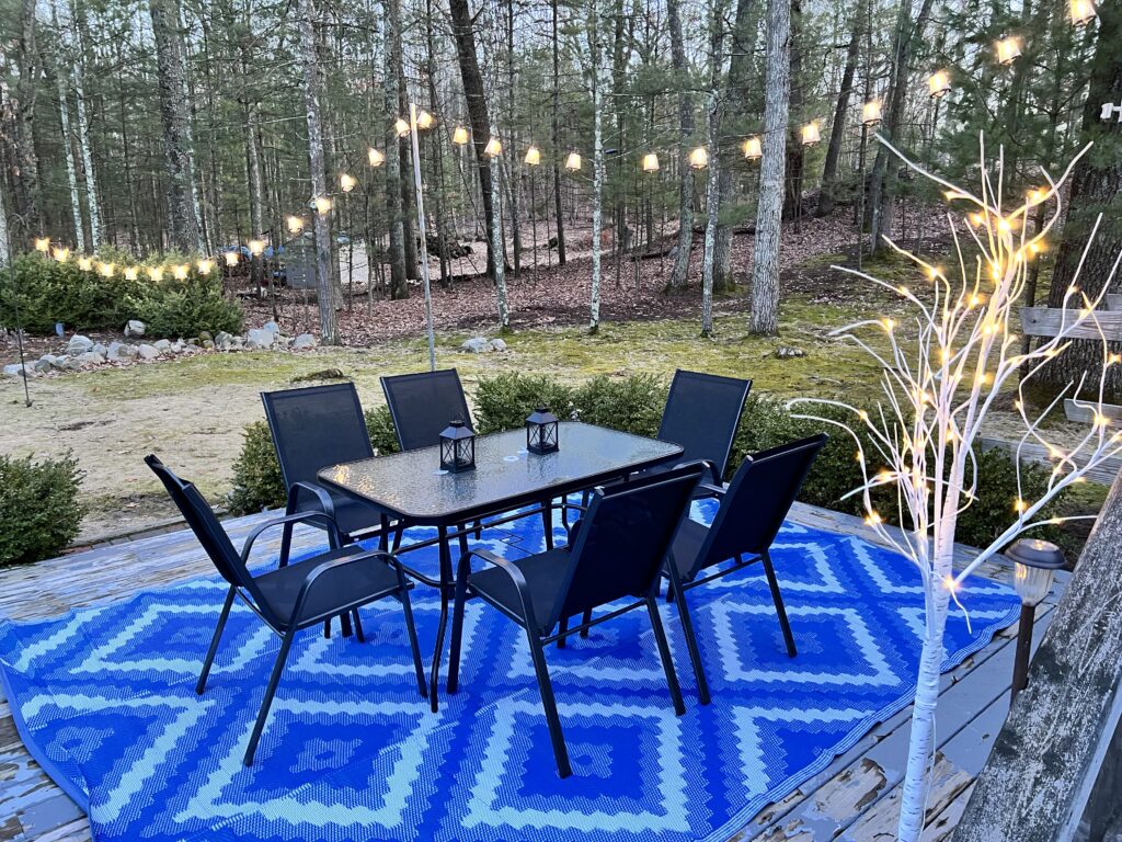 A table and chairs on top of a blue rug.