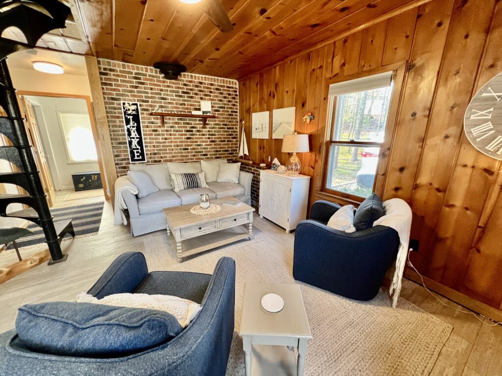 A living room with wood paneled walls and furniture.