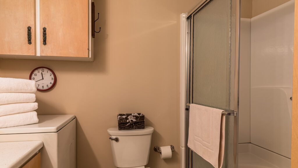 A bathroom with a toilet and shower stall.